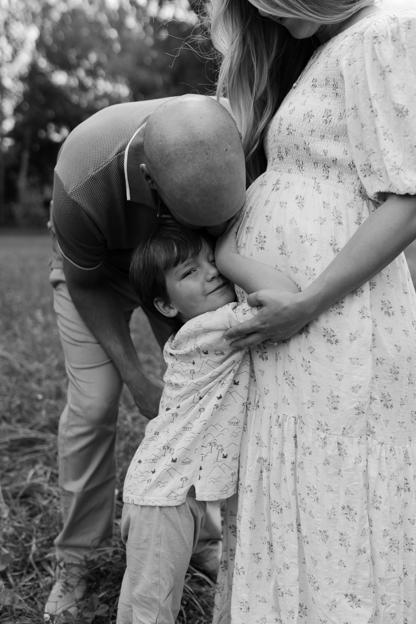 Photo de maternité avec les enfants câlinant le ventre de leur maman