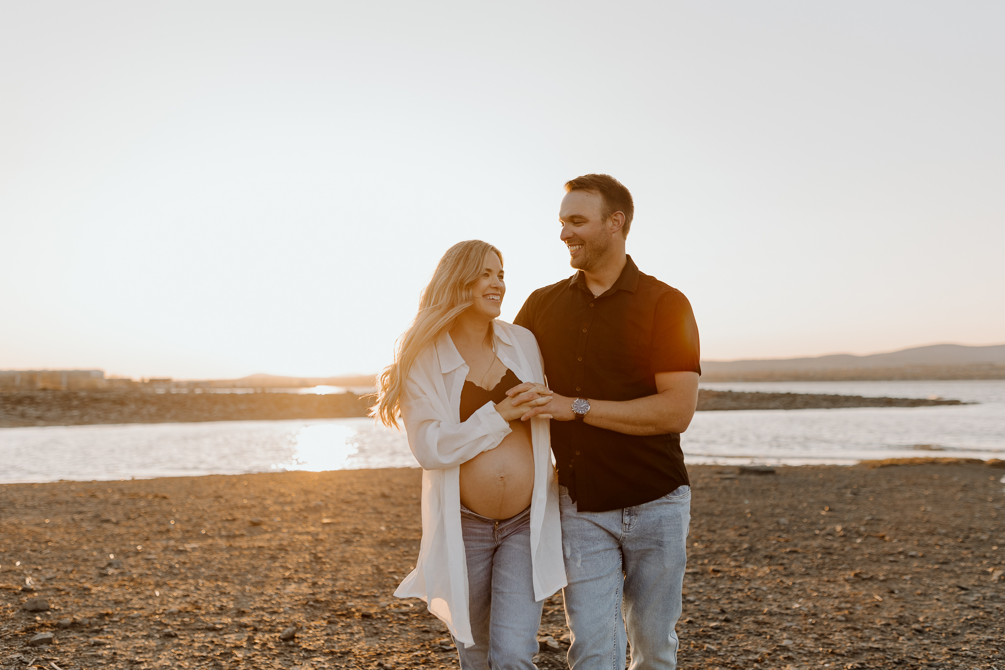 Photo spontanée d’une famille en séance maternité au coucher du soleil