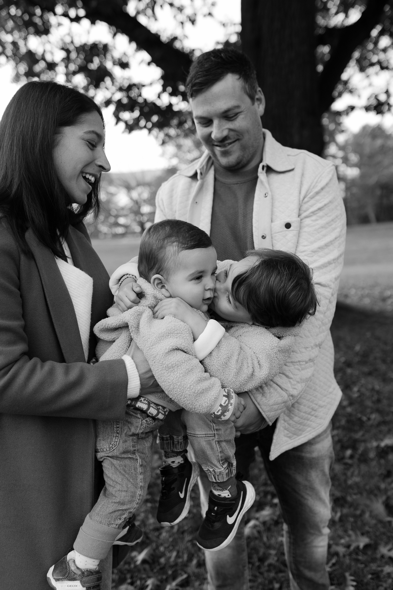 Séance famille à Québec – maman et son papa tenant ses deux enfants en lumière naturelle