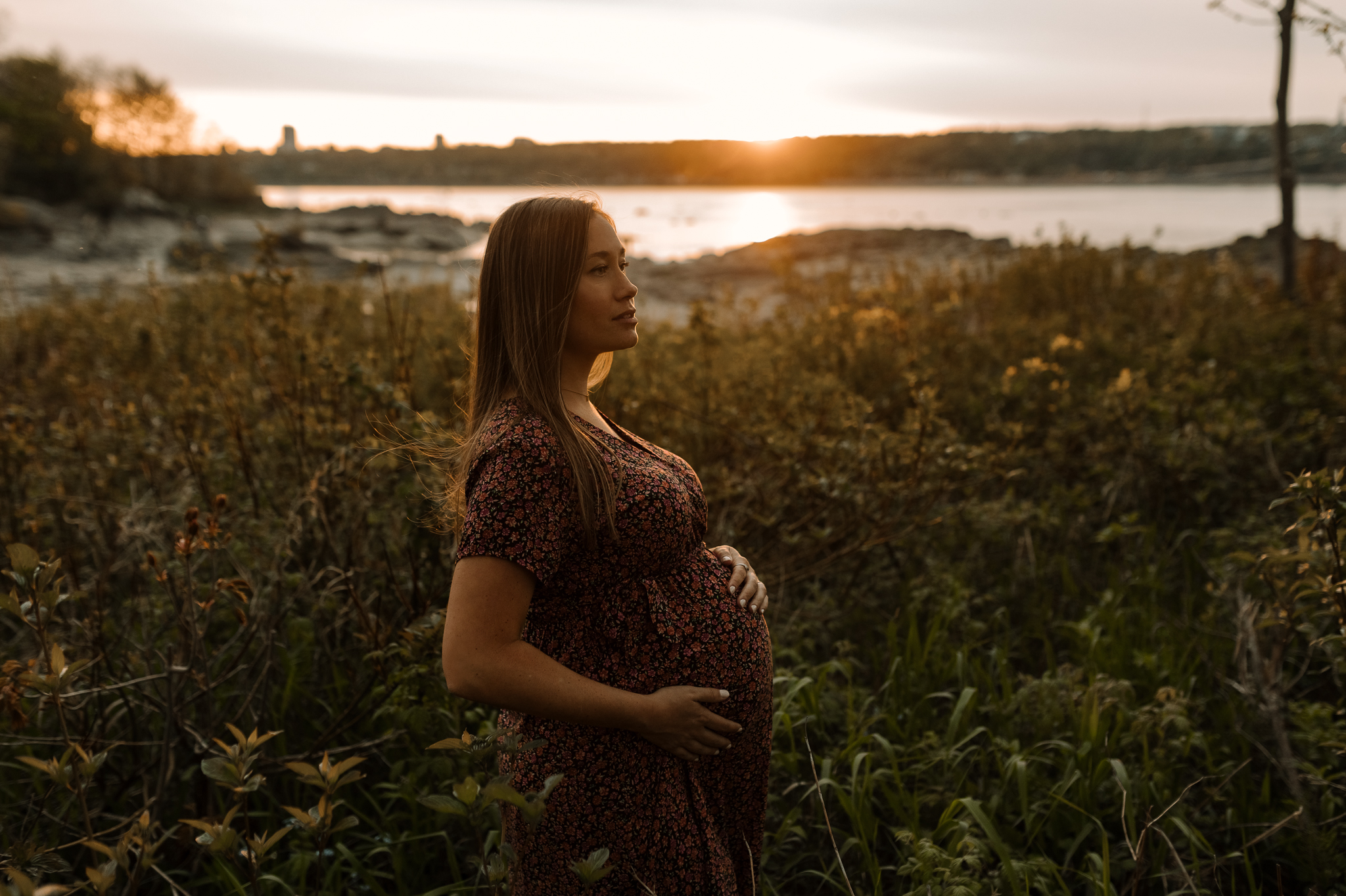 Photo spontanée d’une famille en séance maternité au coucher du soleil