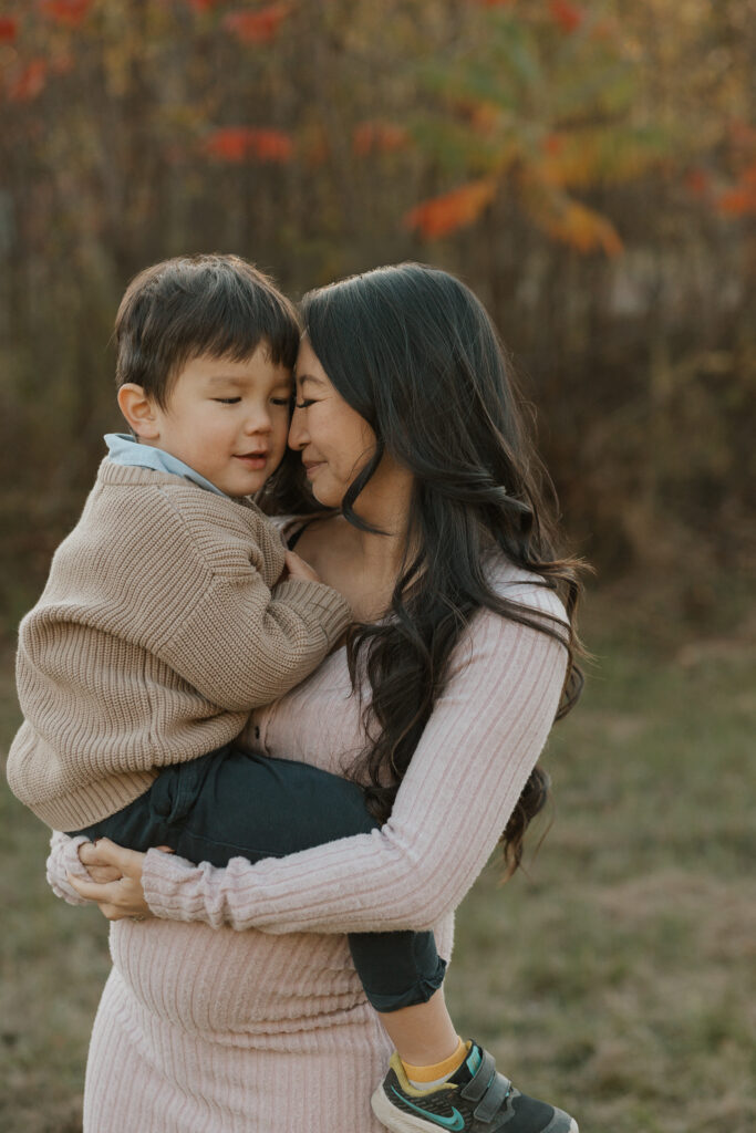 Séance maternité en plein air avec la famille réunie autour de la future maman